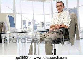 Stock Photo - businessman sitting 
at desk in spacious 
office. fotosearch 
- search stock 
photos, pictures, 
images, and photo 
clipart