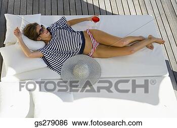 Stock Photo - woman relaxing 
on sunbed. fotosearch 
- search stock 
photos, pictures, 
images, and photo 
clipart