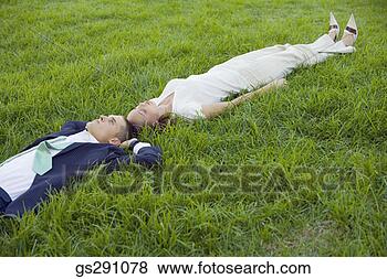 Stock Photo - businesspeople 
lying down in 
grass. fotosearch 
- search stock 
photos, pictures, 
images, and photo 
clipart