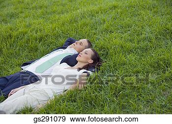 Stock Photograph - businesspeople 
lying down in 
grass. fotosearch 
- search stock 
photos, pictures, 
images, and photo 
clipart