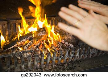 Stock Photo - person warming 
hands by fireplace. 
fotosearch - search 
stock photos, 
pictures, images, 
and photo clipart