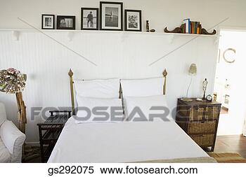 Stock Image - picture frames 
on shelf above 
bed. fotosearch 
- search stock 
photos, pictures, 
images, and photo 
clipart