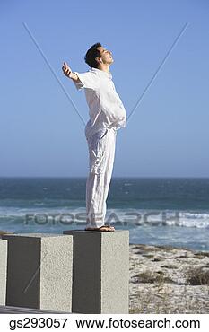 Picture - carefree man standing 
on seashore. fotosearch 
- search stock 
photos, pictures, 
images, and photo 
clipart