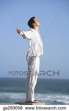 Stock Photo - carefree man standing 
on seashore. fotosearch 
- search stock 
photos, pictures, 
images, and photo 
clipart