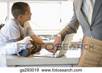 Stock Photograph - father and son 
using laptop in 
kitchen. fotosearch 
- search stock 
photos, pictures, 
images, and photo 
clipart