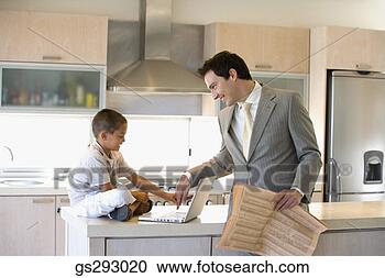 Stock Photography - father and son 
using laptop in 
kitchen. fotosearch 
- search stock 
photos, pictures, 
images, and photo 
clipart