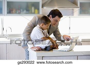 Stock Photo - father and son 
using laptop in 
kitchen. fotosearch 
- search stock 
photos, pictures, 
images, and photo 
clipart