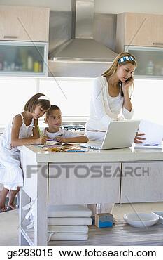Stock Image - mother on cell 
phone with children 
in kitchen. fotosearch 
- search stock 
photos, pictures, 
images, and photo 
clipart