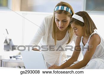 Stock Photo - mother and daughter 
using laptop in 
kitchen. fotosearch 
- search stock 
photos, pictures, 
images, and photo 
clipart