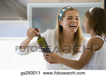 Stock Photography - smiling mother 
taking bottle 
from daughter. 
fotosearch - search 
stock photos, 
pictures, images, 
and photo clipart