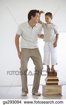 Stock Photo - son standing next 
to father on stack 
of books. fotosearch 
- search stock 
photos, pictures, 
images, and photo 
clipart