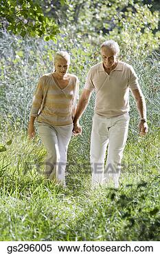 Stock Image - couple holding 
hands in field. 
fotosearch - search 
stock photos, 
pictures, images, 
and photo clipart