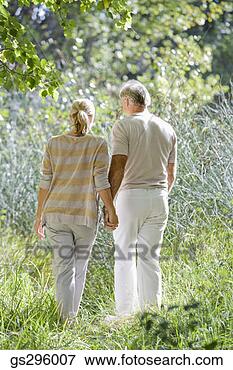 Picture - couple holding 
hands in field. 
fotosearch - search 
stock photos, 
pictures, images, 
and photo clipart