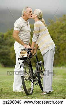 Stock Photo - couple kissing 
by bike in field. 
fotosearch - search 
stock photos, 
pictures, images, 
and photo clipart
