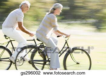 Stock Photo - couple riding 
bikes. fotosearch 
- search stock 
photos, pictures, 
images, and photo 
clipart