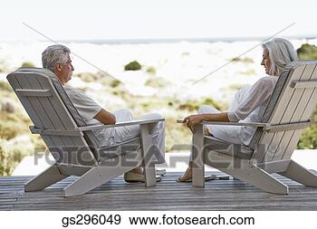 Stock Photograph - couple sitting 
in chairs by beach. 
fotosearch - search 
stock photos, 
pictures, images, 
and photo clipart