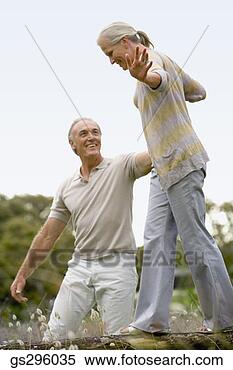 Stock Image - man helping woman 
balance. fotosearch 
- search stock 
photos, pictures, 
images, and photo 
clipart