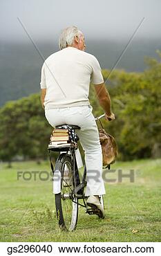Stock Photography - man riding bike 
in field. fotosearch 
- search stock 
photos, pictures, 
images, and photo 
clipart