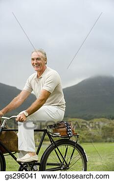 Stock Photography - man riding bike 
through field. 
fotosearch - search 
stock photos, 
pictures, images, 
and photo clipart