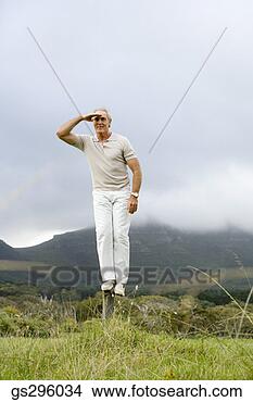Stock Photo - man standing on 
rock with hand 
over eyes. fotosearch 
- search stock 
photos, pictures, 
images, and photo 
clipart