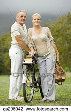 Stock Photo - portrait of couple 
by bike in field. 
fotosearch - search 
stock photos, 
pictures, images, 
and photo clipart