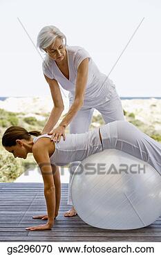 Stock Photography - teacher helping 
woman on exercise 
ball. fotosearch 
- search stock 
photos, pictures, 
images, and photo 
clipart