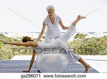 Stock Photography - teacher helping 
woman on exercise 
ball. fotosearch 
- search stock 
photos, pictures, 
images, and photo 
clipart