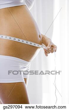 Stock Photo - pregnant woman 
measuring stomach. 
fotosearch - search 
stock photos, 
pictures, images, 
and photo clipart