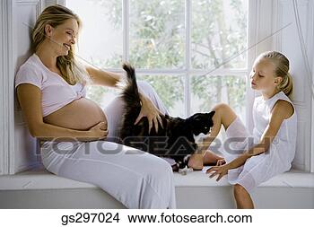 Stock Photo - pregnant woman 
sitting with daughter 
and cat. fotosearch 
- search stock 
photos, pictures, 
images, and photo 
clipart