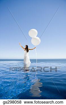 Stock Photo - woman holding 
balloons in infinity 
pool. fotosearch 
- search stock 
photos, pictures, 
images, and photo 
clipart