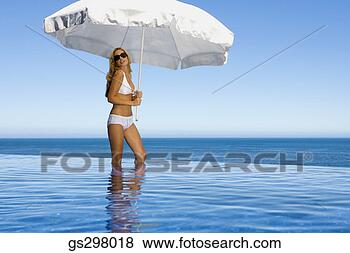 Stock Photo - woman holding 
umbrella in infinity 
pool. fotosearch 
- search stock 
photos, pictures, 
images, and photo 
clipart