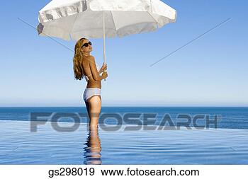 Stock Photograph - woman holding 
umbrella in infinity 
pool. fotosearch 
- search stock 
photos, pictures, 
images, and photo 
clipart