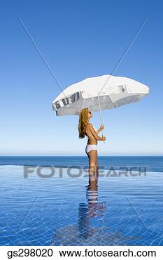 Stock Photography - woman holding 
umbrella in infinity 
pool. fotosearch 
- search stock 
photos, pictures, 
images, and photo 
clipart