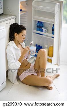 Stock Photography - woman eating near 
open refrigerator. 
fotosearch - search 
stock photos, 
pictures, images, 
and photo clipart
