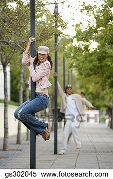 Stock Image - woman swinging 
on pole outdoors. 
fotosearch - search 
stock photos, 
pictures, images, 
and photo clipart