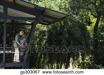 Picture - couple using laptop 
in house near 
forest. fotosearch 
- search stock 
photos, pictures, 
images, and photo 
clipart