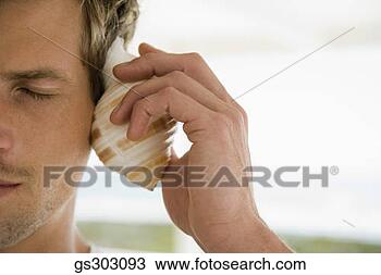 Stock Photo - man listening 
to seashell. fotosearch 
- search stock 
photos, pictures, 
images, and photo 
clipart