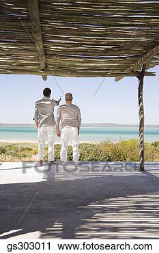 Stock Photography - men looking out 
to ocean from 
patio. fotosearch 
- search stock 
photos, pictures, 
images, and photo 
clipart