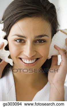 Stock Photo - smiling woman 
listening to seashells. 
fotosearch - search 
stock photos, 
pictures, images, 
and photo clipart
