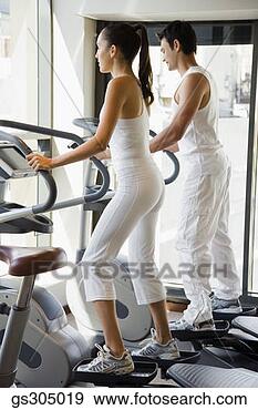 Stock Photograph - couple using elliptical 
machines. fotosearch 
- search stock 
photos, pictures, 
images, and photo 
clipart