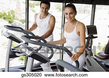 Stock Photography - couple using elliptical 
machines. fotosearch 
- search stock 
photos, pictures, 
images, and photo 
clipart