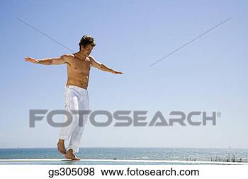 Stock Photo - man balancing 
on infinity pool. 
fotosearch - search 
stock photos, 
pictures, images, 
and photo clipart