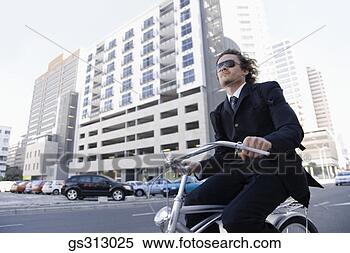 Stock Image - businessman riding 
bicycle along 
city street. fotosearch 
- search stock 
photos, pictures, 
images, and photo 
clipart