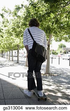 Stock Photo - man riding skateboard 
on sidewalk. fotosearch 
- search stock 
photos, pictures, 
images, and photo 
clipart