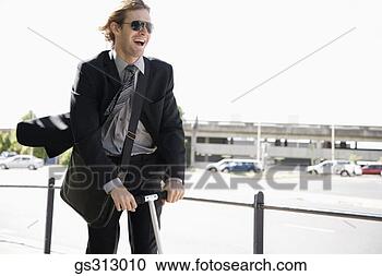 Stock Photography - smiling man riding 
scooter outdoors. 
fotosearch - search 
stock photos, 
pictures, images, 
and photo clipart