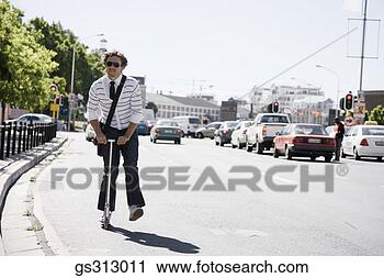 Stock Photography - smiling man riding 
scooter. fotosearch 
- search stock 
photos, pictures, 
images, and photo 
clipart