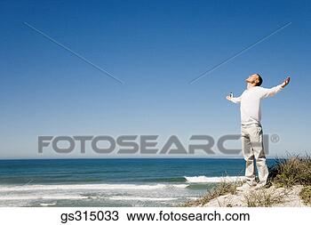Stock Photo - man at beach with 
arms outstretched. 
fotosearch - search 
stock photos, 
pictures, images, 
and photo clipart