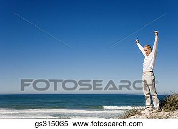 Stock Image - man at beach with 
arms raised. fotosearch 
- search stock 
photos, pictures, 
images, and photo 
clipart