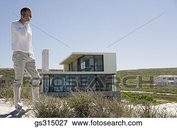 Picture - man at beach with 
cell phone. fotosearch 
- search stock 
photos, pictures, 
images, and photo 
clipart