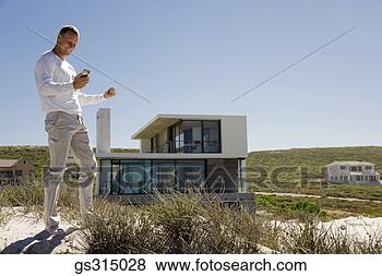 Stock Photo - man at beach with 
cell phone. fotosearch 
- search stock 
photos, pictures, 
images, and photo 
clipart